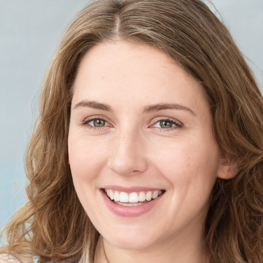 Joyful white young-adult female with long  brown hair and green eyes