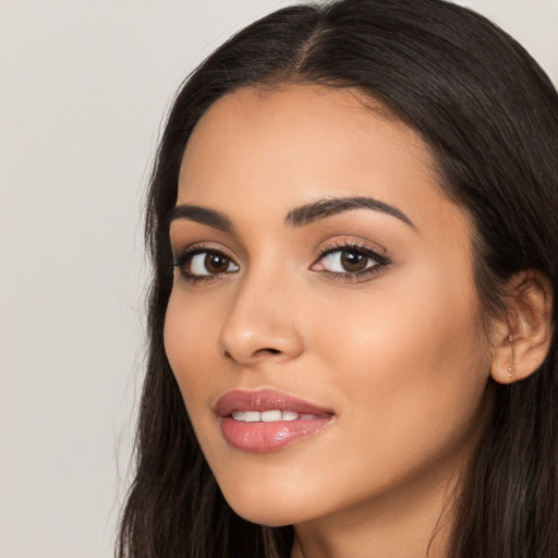 Joyful latino young-adult female with long  black hair and brown eyes