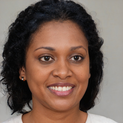 Joyful black young-adult female with medium  brown hair and brown eyes