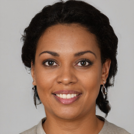Joyful black young-adult female with short  brown hair and brown eyes