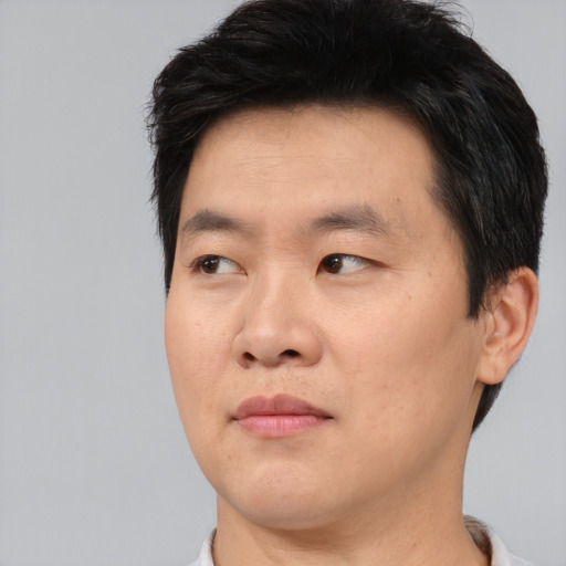 Joyful asian young-adult male with short  black hair and brown eyes