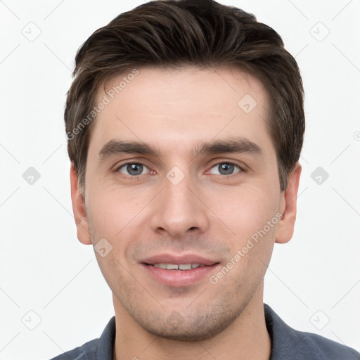 Joyful white young-adult male with short  brown hair and grey eyes