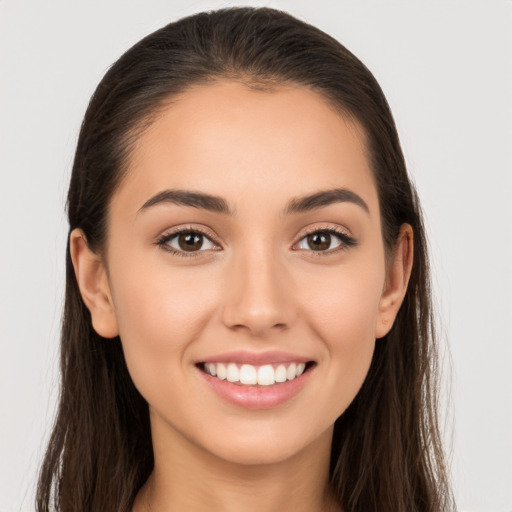 Joyful white young-adult female with long  brown hair and brown eyes