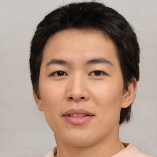 Joyful asian young-adult male with short  black hair and brown eyes