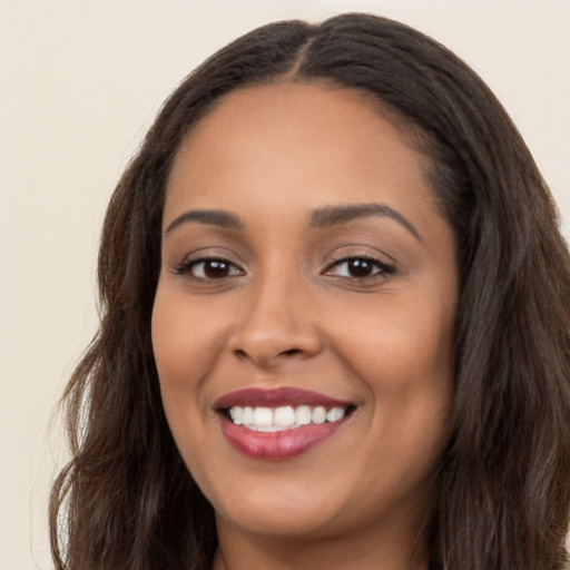 Joyful latino young-adult female with long  brown hair and brown eyes