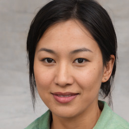 Joyful asian young-adult female with medium  brown hair and brown eyes