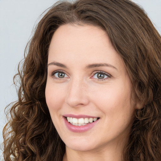 Joyful white young-adult female with long  brown hair and green eyes