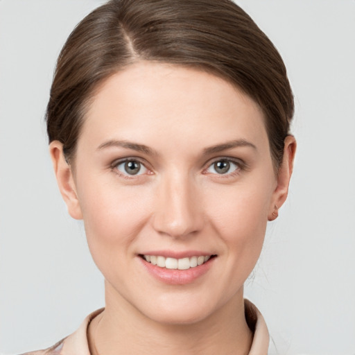 Joyful white young-adult female with short  brown hair and grey eyes