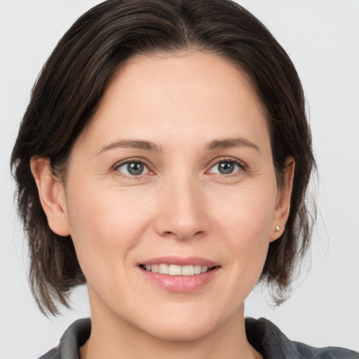 Joyful white adult female with medium  brown hair and grey eyes