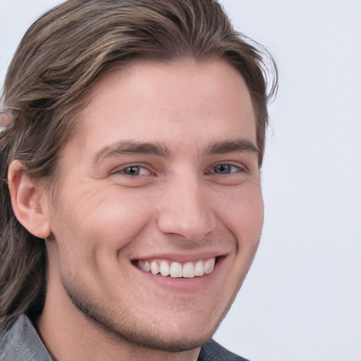 Joyful white young-adult male with short  brown hair and blue eyes