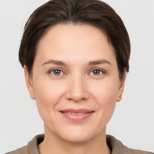 Joyful white young-adult female with short  brown hair and grey eyes