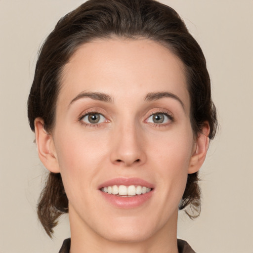 Joyful white young-adult female with medium  brown hair and green eyes