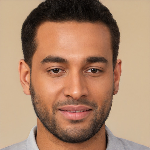 Joyful latino young-adult male with short  brown hair and brown eyes