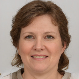 Joyful white adult female with medium  brown hair and grey eyes