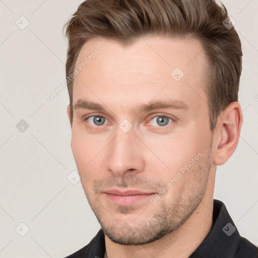 Joyful white young-adult male with short  brown hair and grey eyes