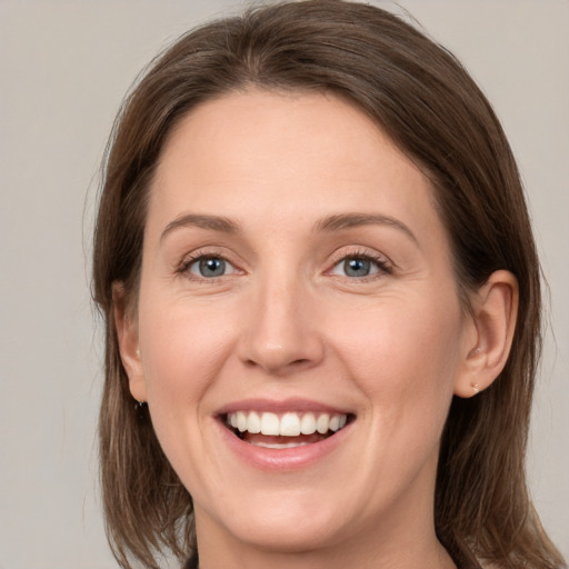 Joyful white young-adult female with medium  brown hair and grey eyes