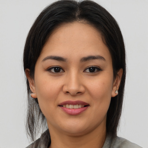 Joyful latino young-adult female with medium  brown hair and brown eyes