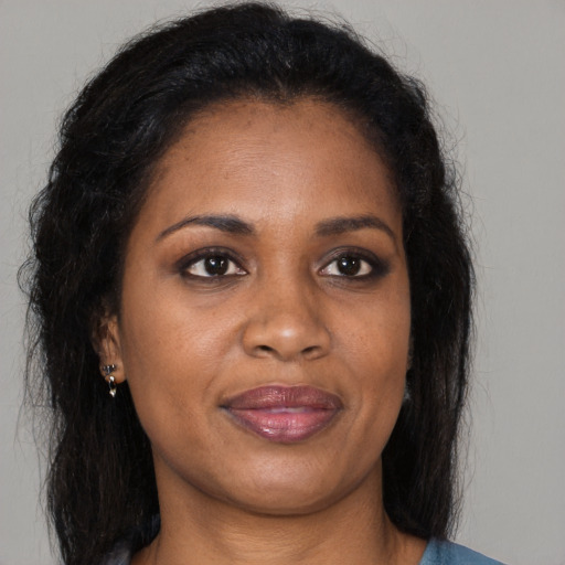 Joyful black adult female with long  brown hair and brown eyes