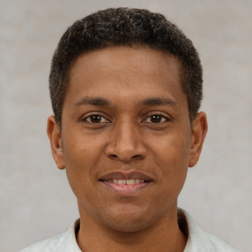 Joyful latino young-adult male with short  brown hair and brown eyes
