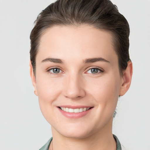 Joyful white young-adult female with short  brown hair and grey eyes