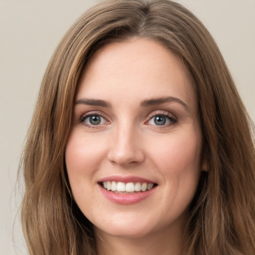 Joyful white young-adult female with long  brown hair and green eyes