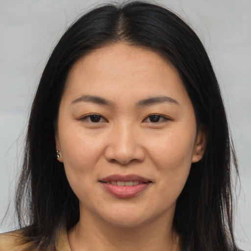 Joyful asian young-adult female with long  brown hair and brown eyes