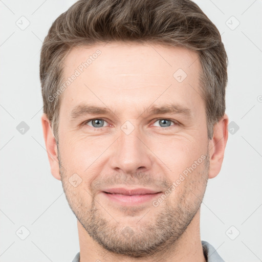 Joyful white young-adult male with short  brown hair and grey eyes