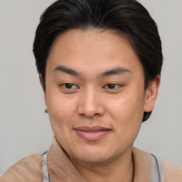 Joyful asian young-adult male with short  brown hair and brown eyes