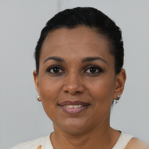Joyful black young-adult female with short  black hair and brown eyes