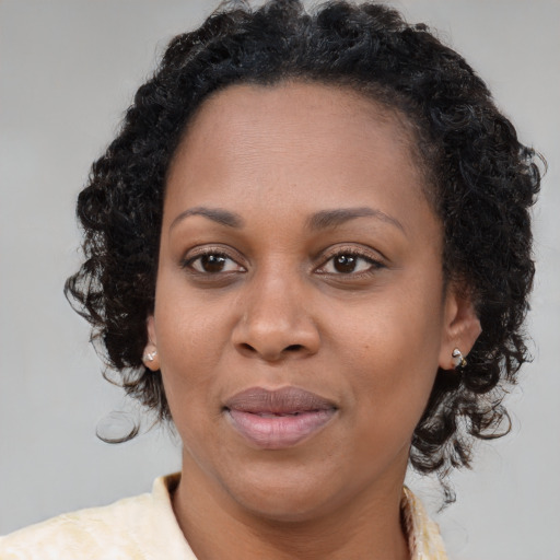 Joyful black adult female with long  brown hair and brown eyes