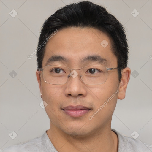 Joyful asian young-adult male with short  brown hair and brown eyes