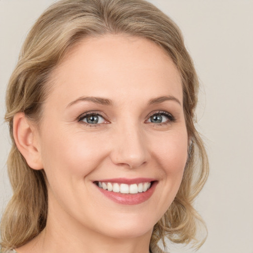 Joyful white young-adult female with medium  brown hair and blue eyes