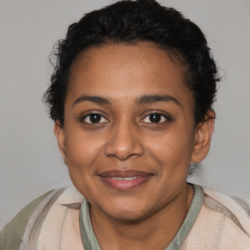 Joyful black young-adult female with short  black hair and brown eyes