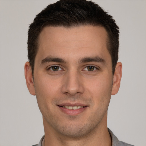 Joyful white young-adult male with short  brown hair and brown eyes