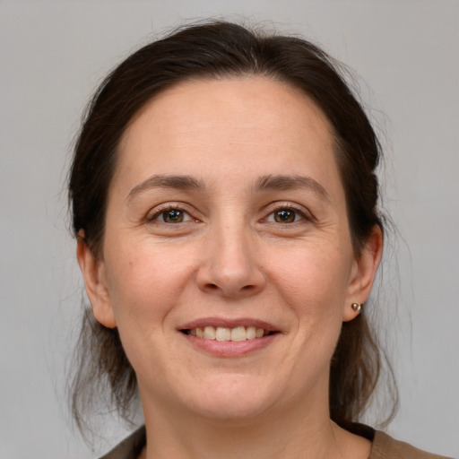 Joyful white adult female with medium  brown hair and grey eyes