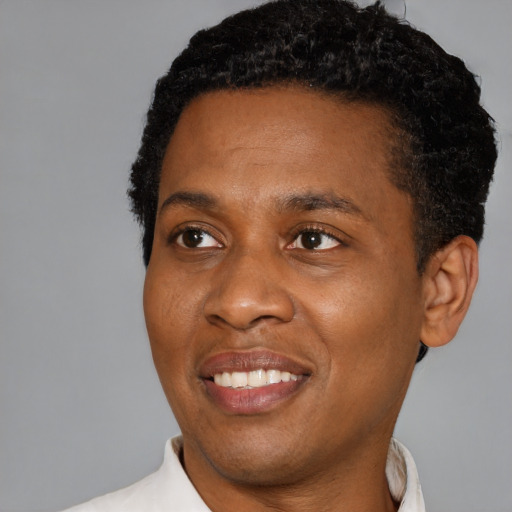 Joyful black young-adult male with short  black hair and brown eyes
