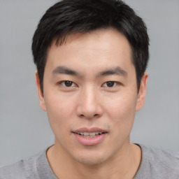 Joyful asian young-adult male with short  black hair and brown eyes