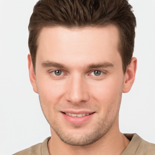 Joyful white young-adult male with short  brown hair and grey eyes