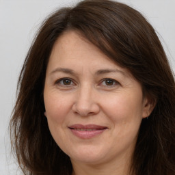 Joyful white adult female with long  brown hair and brown eyes