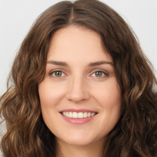 Joyful white young-adult female with long  brown hair and green eyes