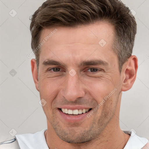 Joyful white adult male with short  brown hair and brown eyes