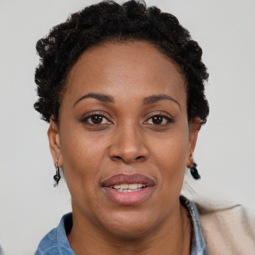 Joyful black adult female with short  brown hair and brown eyes