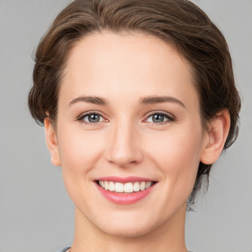 Joyful white young-adult female with medium  brown hair and green eyes