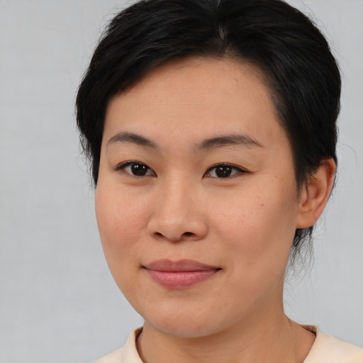 Joyful asian young-adult female with medium  brown hair and brown eyes