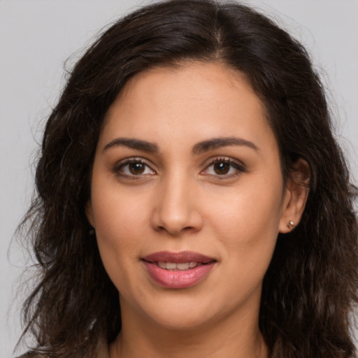 Joyful latino young-adult female with long  brown hair and brown eyes