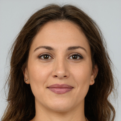 Joyful white adult female with long  brown hair and brown eyes