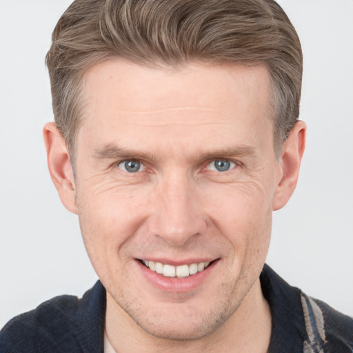 Joyful white adult male with short  brown hair and grey eyes