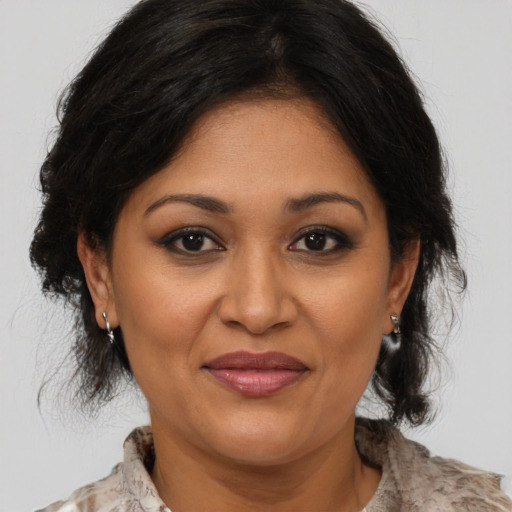 Joyful latino adult female with medium  brown hair and brown eyes
