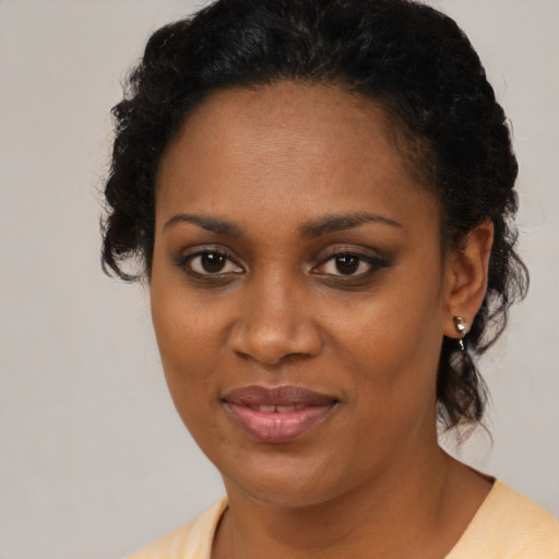 Joyful black young-adult female with medium  brown hair and brown eyes