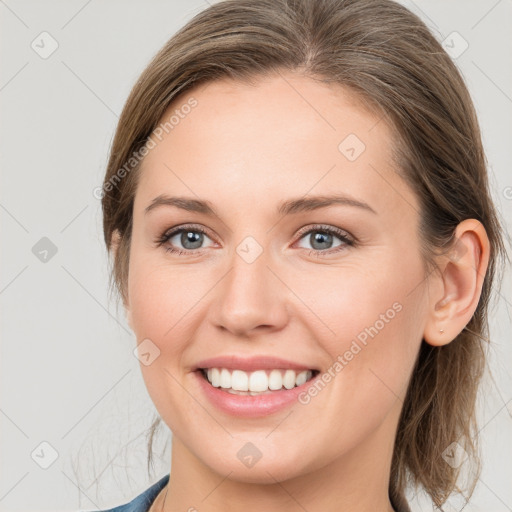 Joyful white young-adult female with medium  brown hair and grey eyes